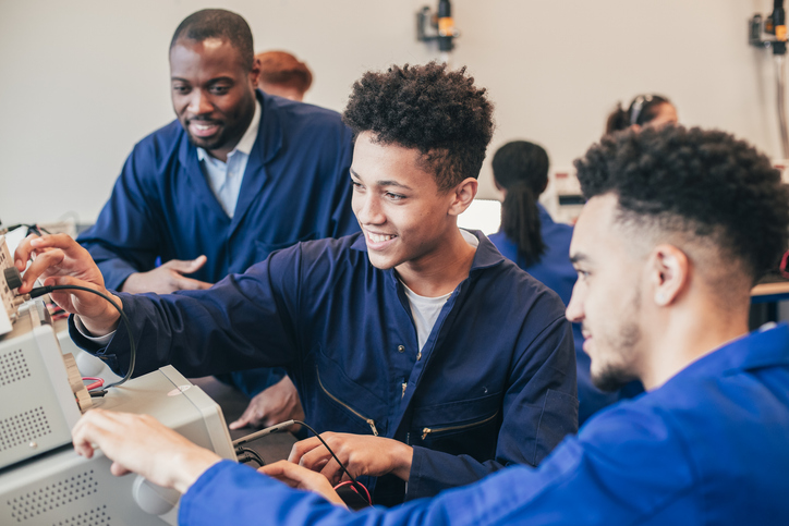Two mixed race engineering students work on a group project together in a workshop