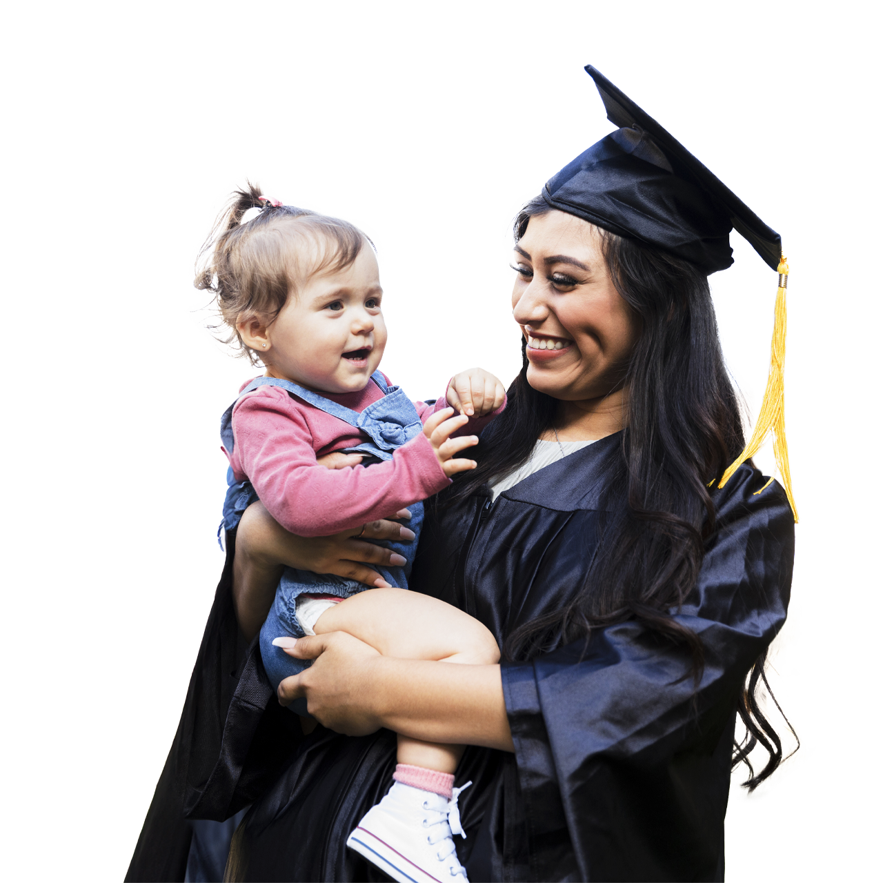 Hispanic graduate in gown holding her daughter smiling.